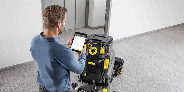 Manage Equipment Through Online Tools Customer uses a tablet to find information on his walk-behind floor scrubber