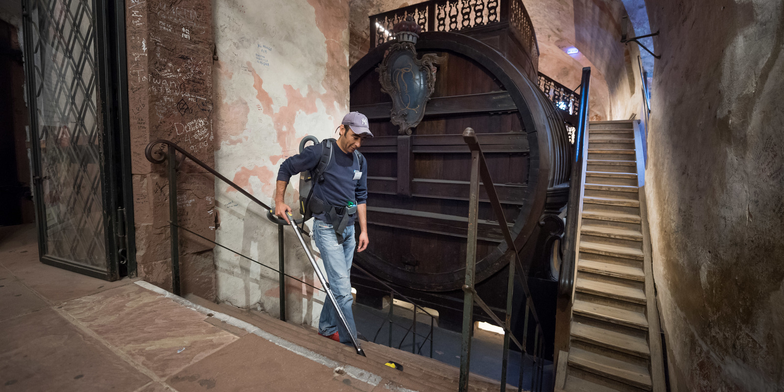 Cleaning of stairs with a backpack vacuum cleaner Man cleans the stairs in the barrel cellar of Heidelberg Castle with a Kärcher backpack vacuum cleaner