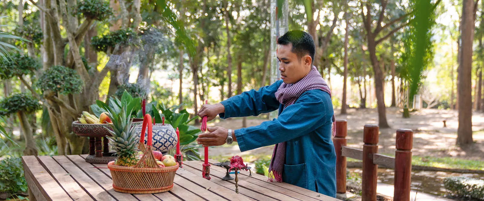 Тайландец зажигает свечи в лесу