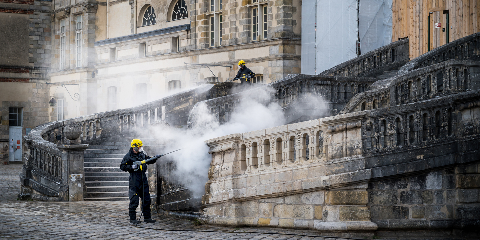 Élimination des substances biologiques à l'escalier en fer-à-cheval Kärcher nettoie le château de Fontainebleau avec des nettoyeurs haute pression à eau chaude