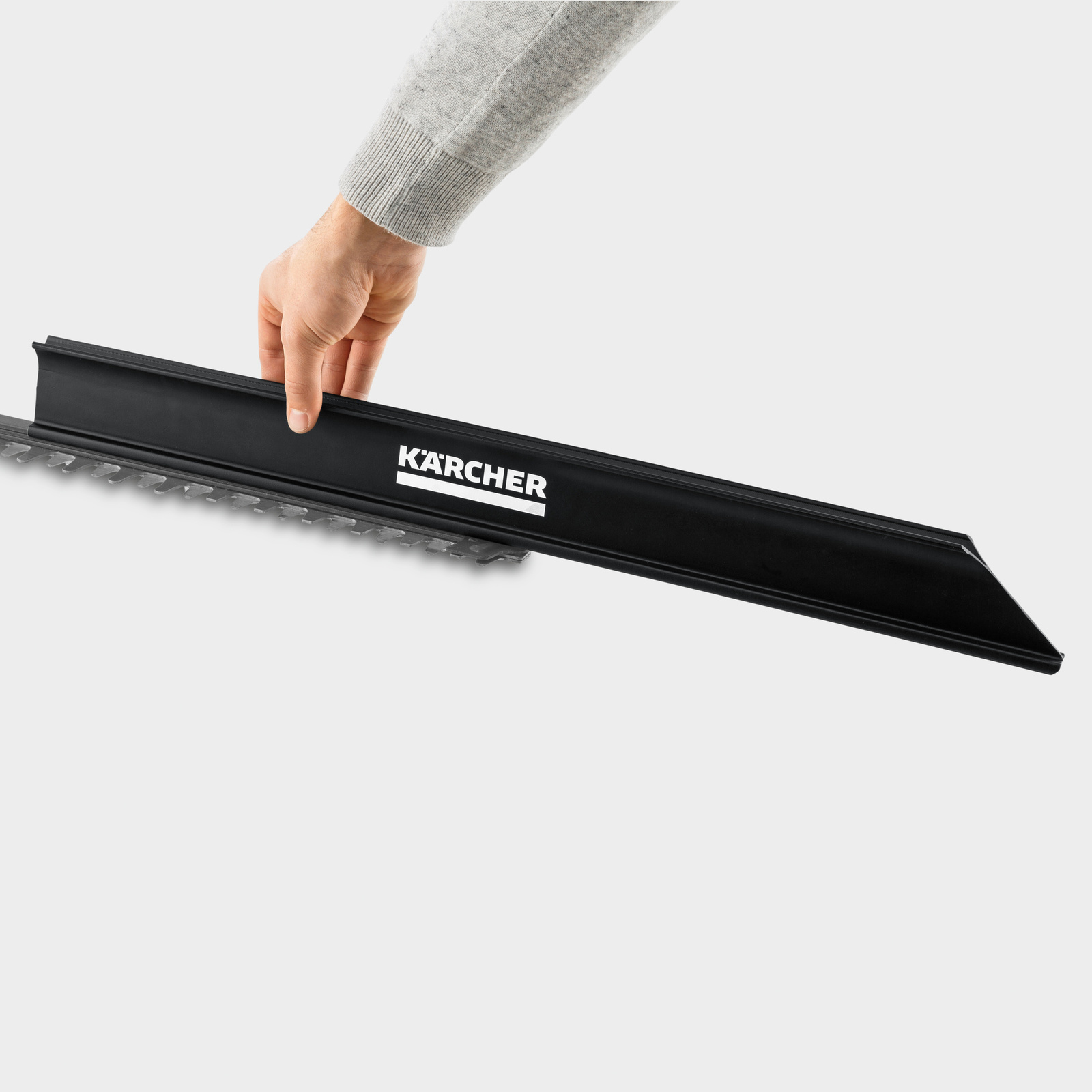 Taille-haies sans fil: un collecteur de déchets Une main montre comment fonctionne le collecteur de déchets du taille-haies sans fil de Kärcher