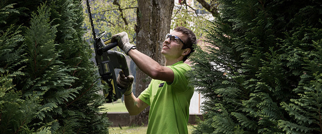 Using a Kärcher electric trimmer on the hedges Murezi uses a Kärcher electric trimmer on the monastery hedges