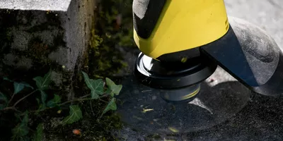 Person removes weeds effortlessly from joints and stair edges with the Kärcher cordless weed remover