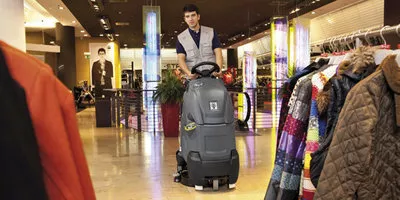 worker cleans clothing store floors using the Chariot™ 2 iScrub 20 Deluxe with ORB Technology