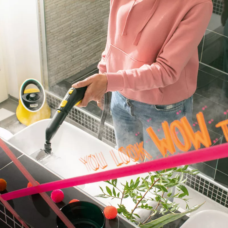 Woman cleaning bathroom using Kärcher steam cleaner SC 2 Deluxe EasyFix