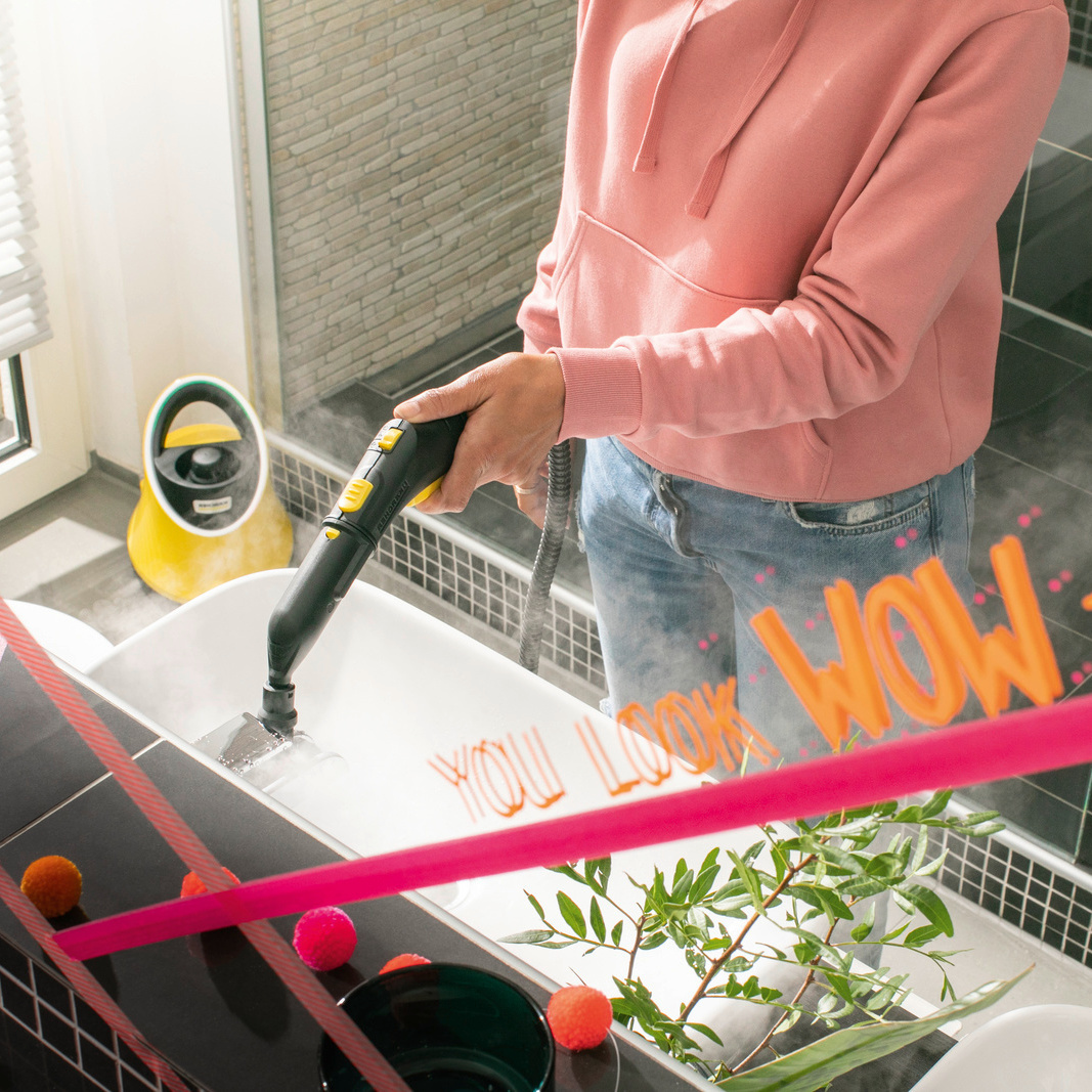 Woman cleaning bathroom using Kärcher steam cleaner SC 2 Deluxe EasyFix