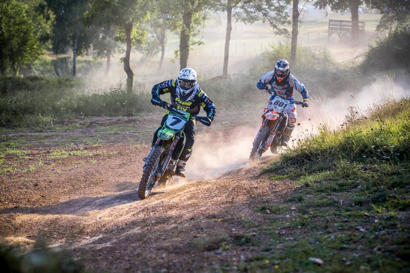 Eine Motocrassfahrerin und ein Motocrossfahrer liefern sich ein Rennen auf der Rennstrecke in Rudersberg.