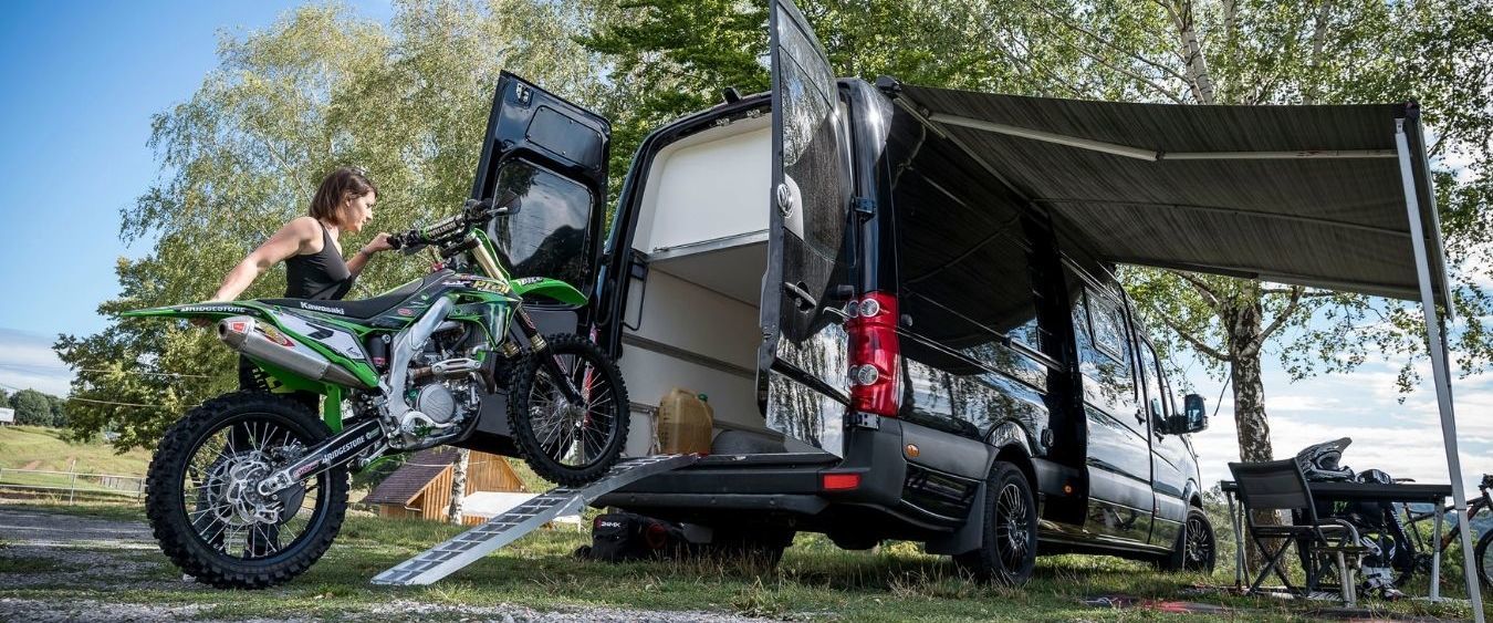 Kärcher Mitarbeiterin Vanessa Helpert lädt ihr schweres Motorrad eigenhändig aus dem Transporter.