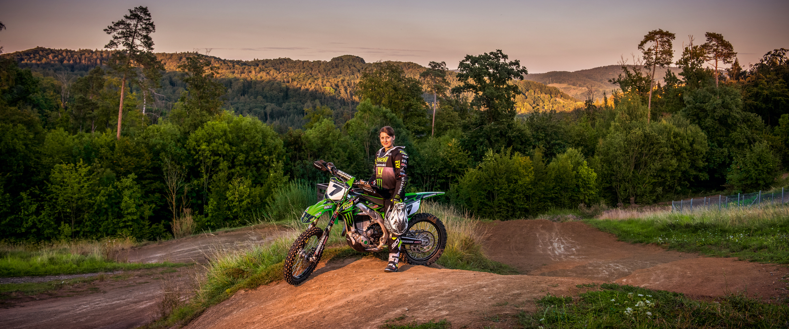 Kärcher Mitarbeiterin Vanessa Helpert posiert mit ihrem Motorrad auf der Rennstrecke für den Fotografen. Den Helm hat sie in der Hand.