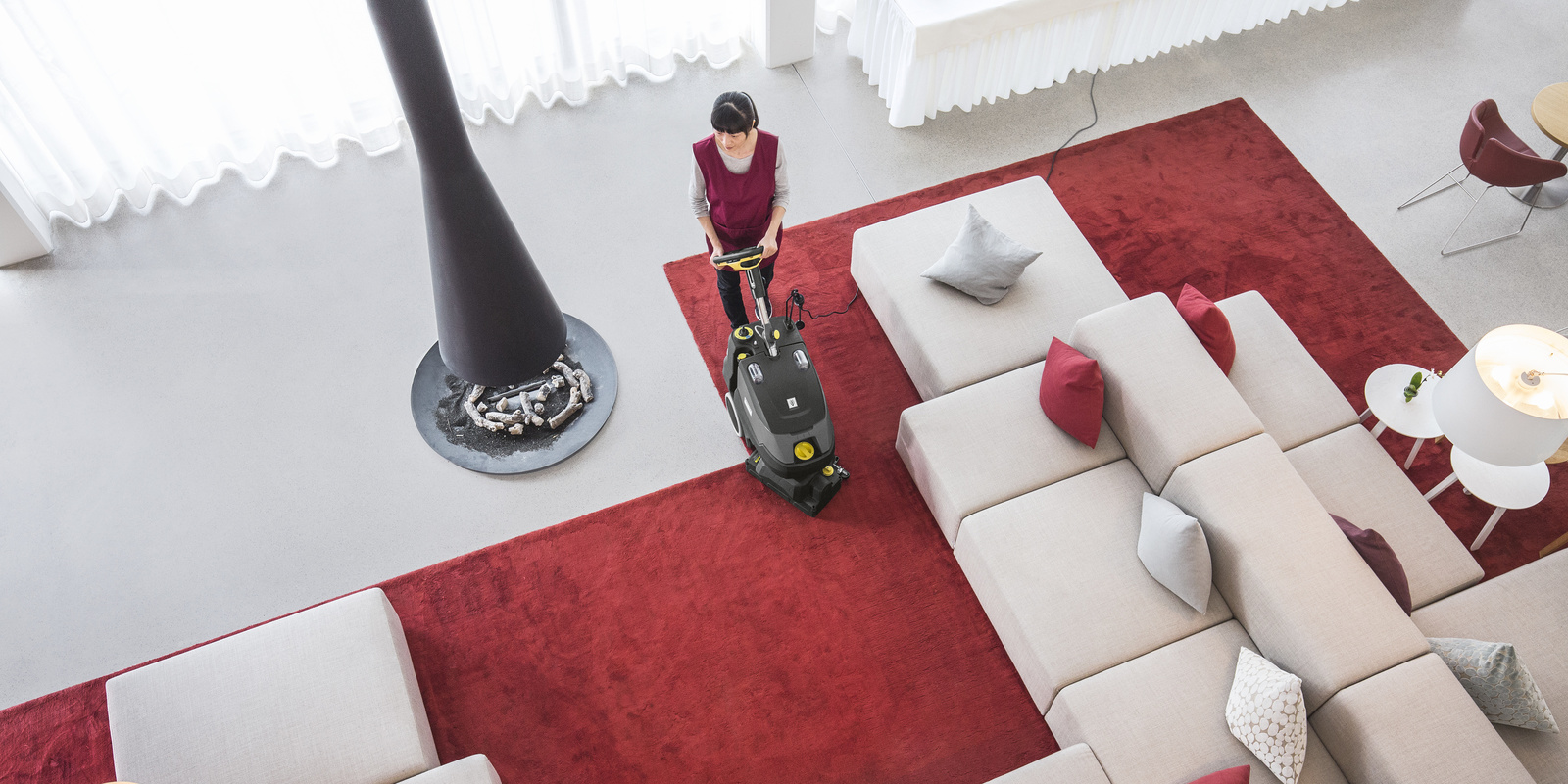 Une femme nettoie un tapis Une femme nettoie un tapis