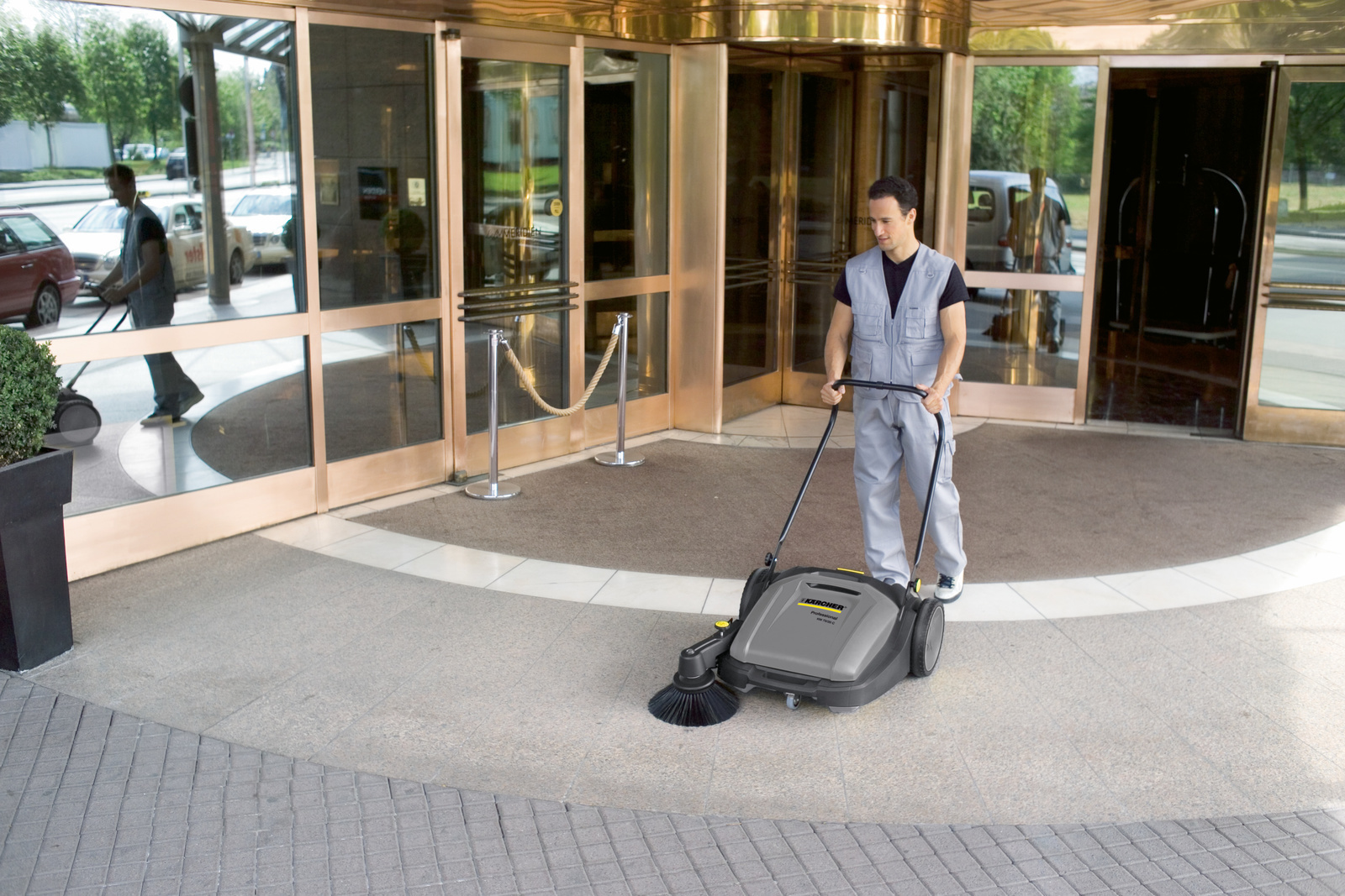 Push vacuum sweeper in use Woman seen cleaning artificial turf using a push vacuum sweeper