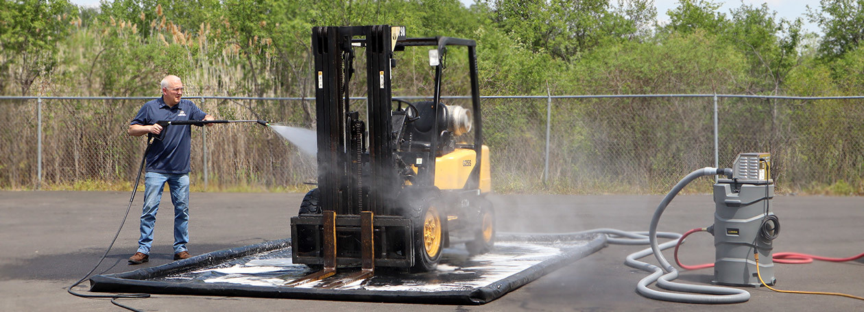 Landa detergents worker cleans a forklift using Landa detergents