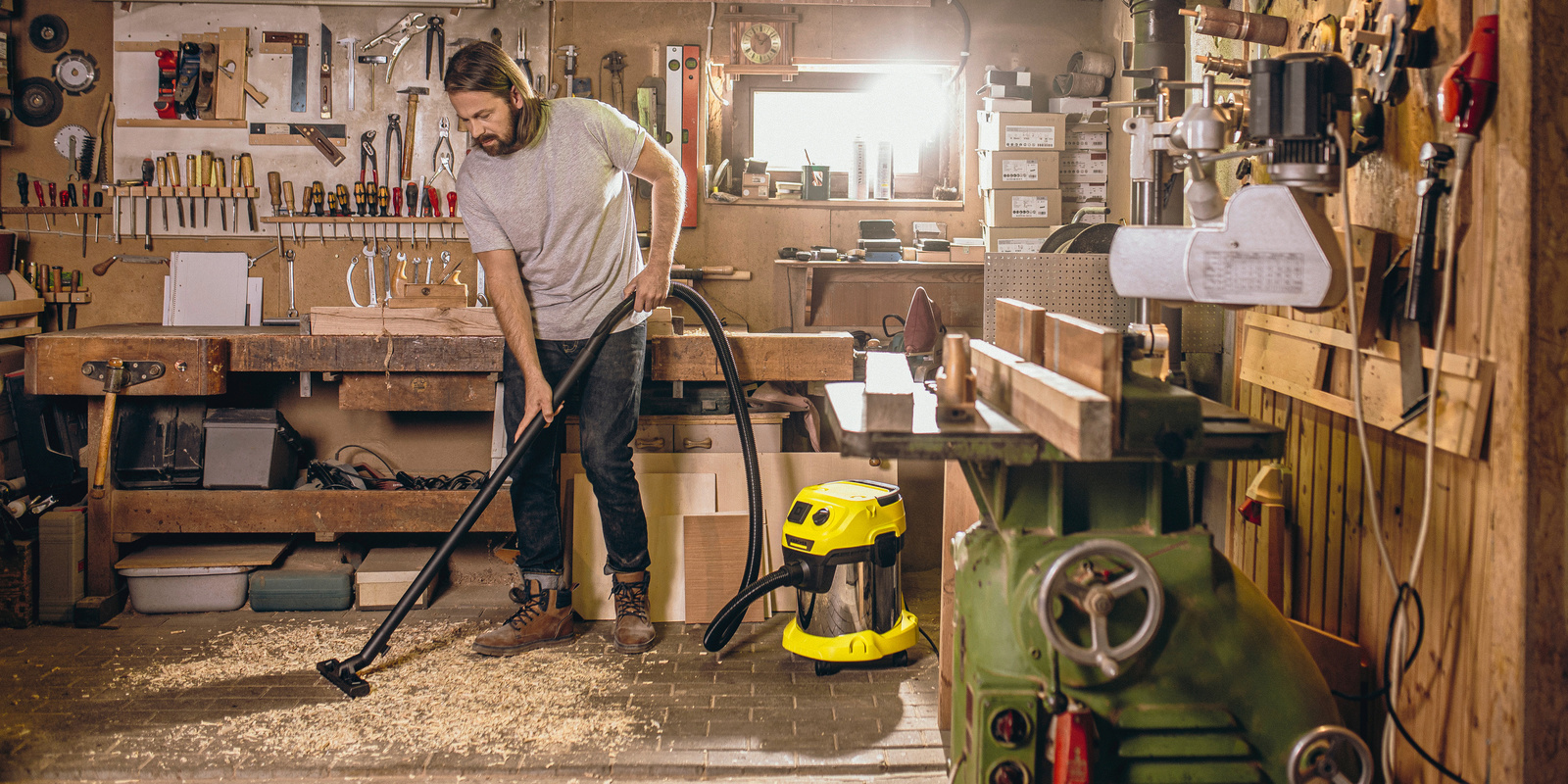 Person cleans workshop with Kärcher WD 3 P S Kärcher WD 3 P S