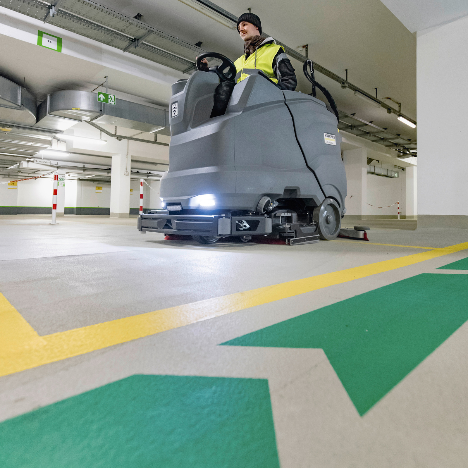 Man reinigt parkeergarage met Kärcher schrobmachine Man reinigt parkeergarage met Kärcher schrobmachine