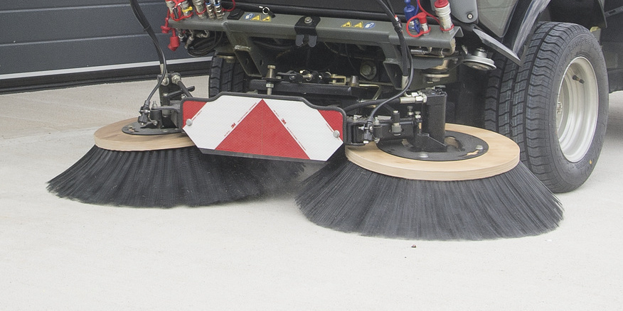 Sweeper with two-brush system cleans a stone floor Sweeper with two-brush system cleans a stone floor