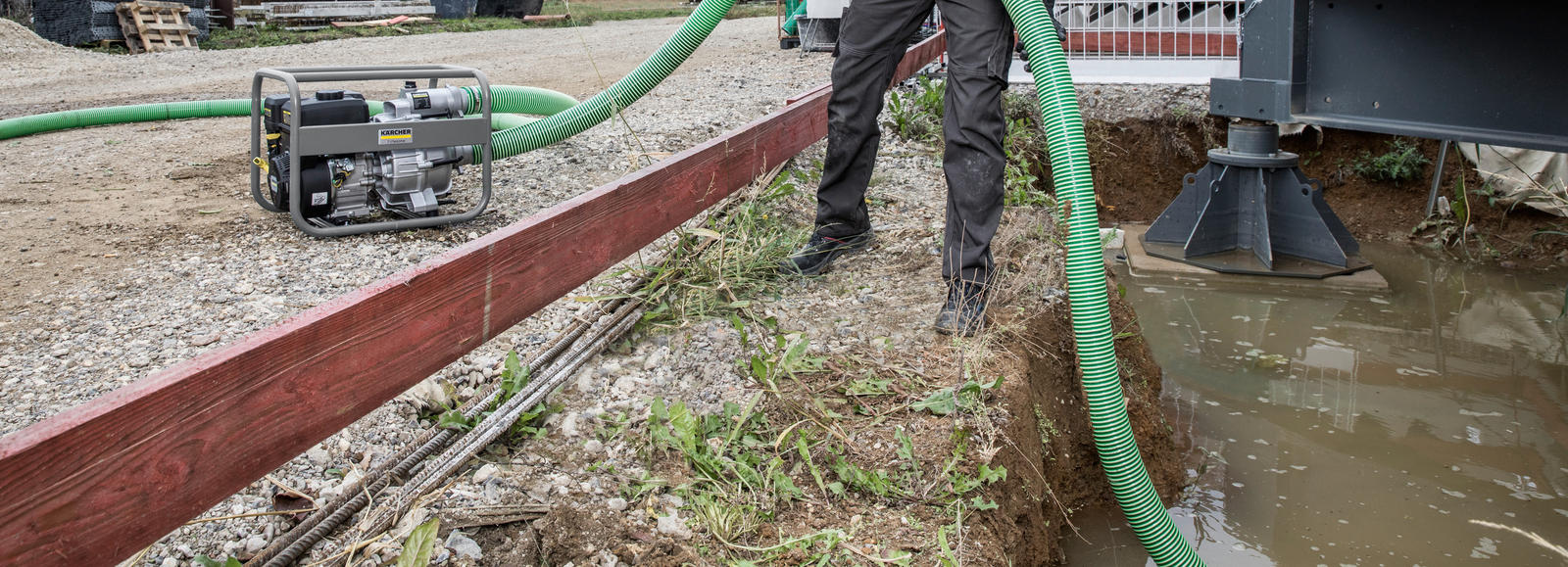 Water wordt weggepompt met behulp van een Kärcher benzine-aangedreven pomp Water wordt weggepompt met behulp van een Kärcher benzine-aangedreven pomp