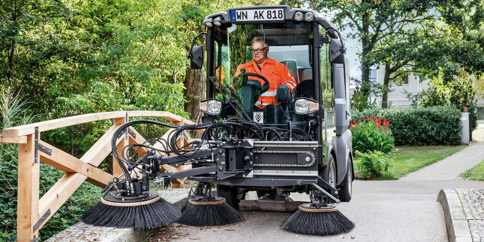 Sweeper with three-brush system cleans a park Sweeper with three-brush system cleans a park