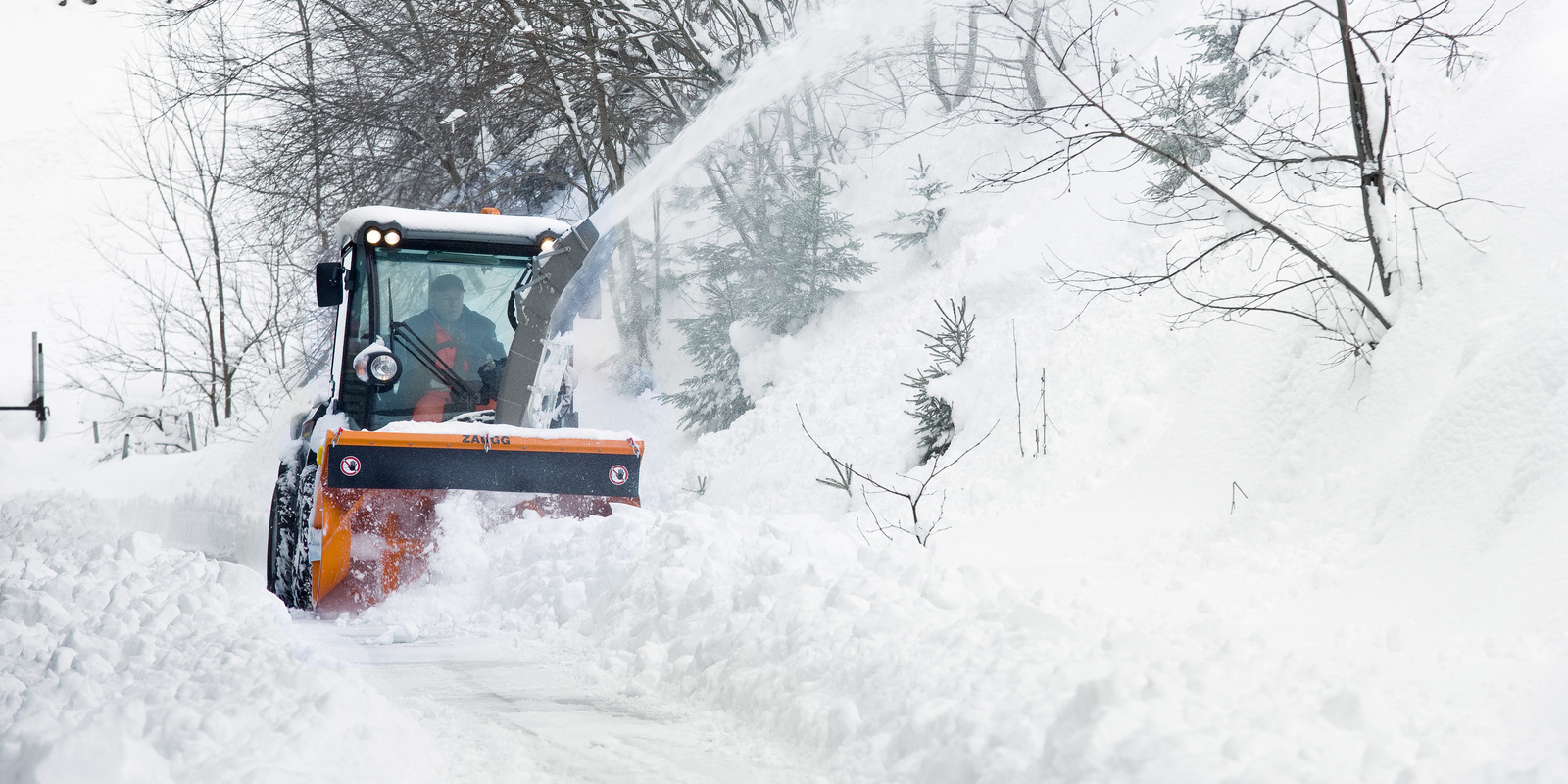 Véhicule porte-outils en mode d'utilisation hivernale lors du déneigement Véhicule porte-outils en mode d'utilisation hivernale lors du déneigement