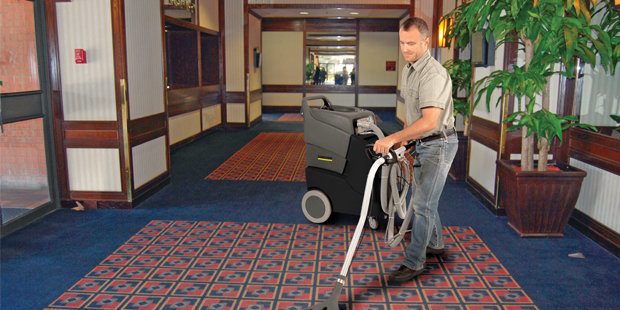 Kärcher Box & Wand Carpet Extractors A worker uses a box & wand carpet extractor in a hotel lobby.