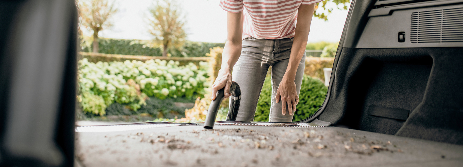 Vrouw gebruikt Karcher alleszuiger Vrouw gebruikt Karcher alleszuiger om auto uit te zuigen