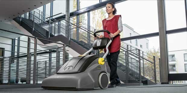 Kärcher Commercial Wide-Area Vacuums A worker uses an CV 66/2 wide-area vacuum in an office building.