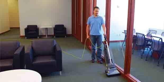 Kärcher Upright Commercial Vacuums A worker uses a Kärcher Sensor® S2 14 HEPA upright vacuum in an office.