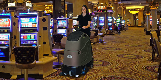 Kärcher Stand-On Vacuums A worker uses a Kärcher Chariot™ 2 iVac 24 ATV stand-on vacuum inside a casino.