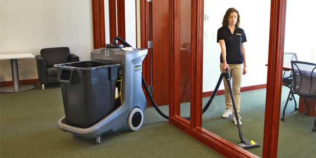 Kärcher CartVac Commercial Vacuums A worker uses a Kärcher ECO! T11 Bp Liner Deluxe CartVac commercial vacuum inside an office.