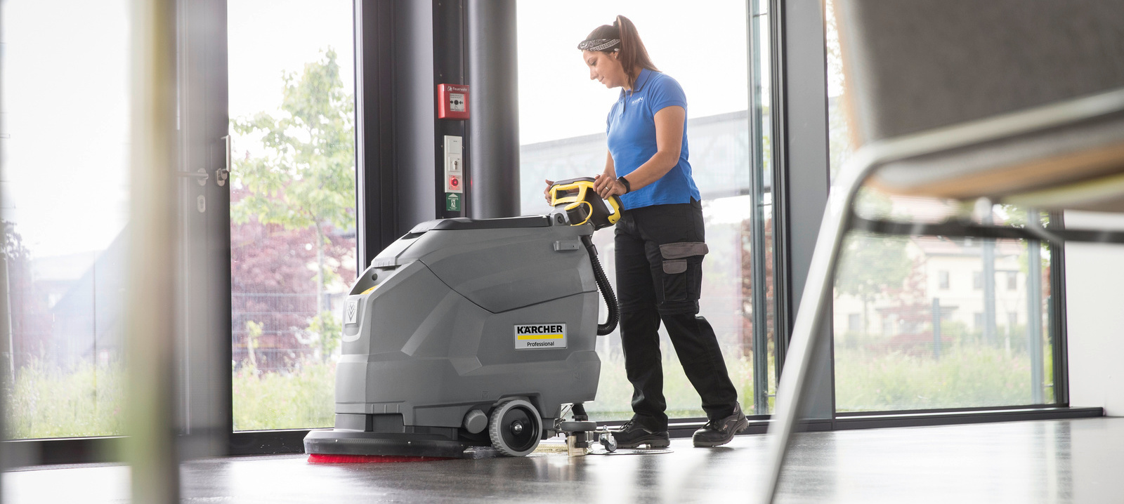Kärcher BD 50/50 walk-behind scrubber Woman cleaning floor with Kärcher BD 50/50 walk-behind scrubber