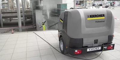 Surface disinfection on a stone wall in a station forecourt using Kärcher HDS Trailer