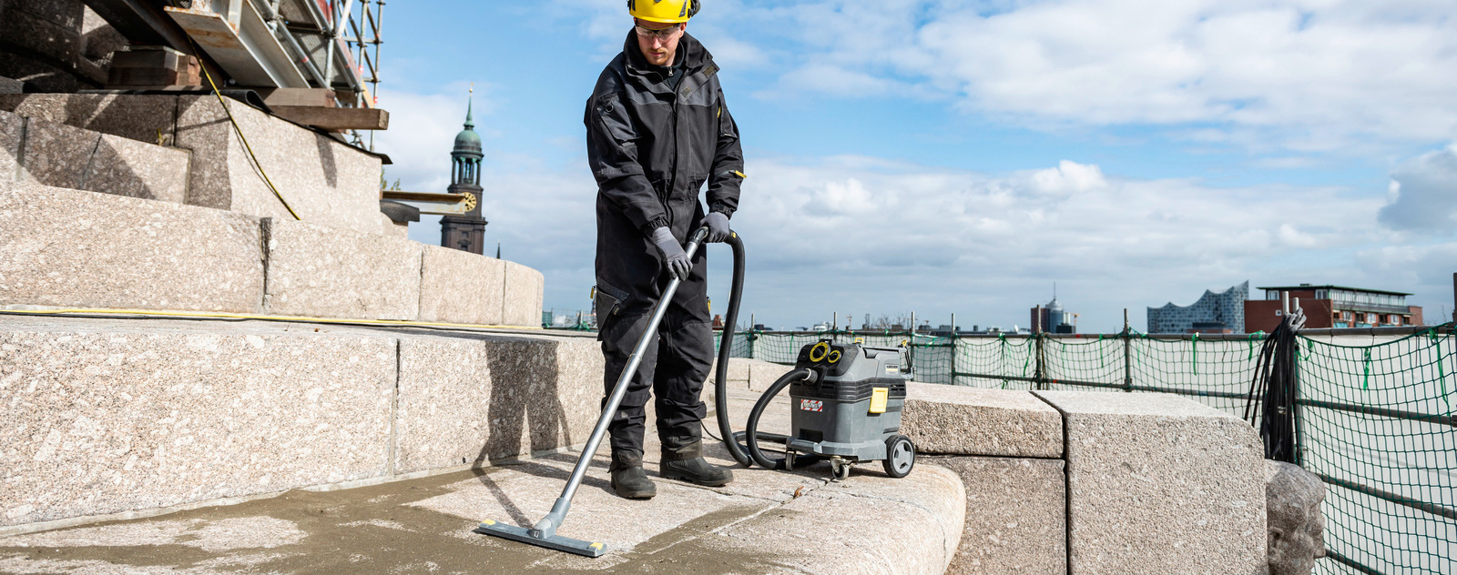 Personne nettoyant un monument avec un aspirateur eau et poussières Kärcher Personne nettoyant un monument avec un aspirateur eau et poussières Kärcher